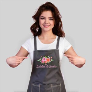 Femme portant un tablier personnalisé avec flocage pro du logo L’atelier de Sophie.