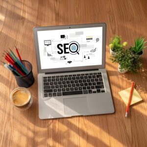 Ordinateur portable affichant le mot SEO sur un bureau en bois, illustrant la rédaction web optimisée SEO.