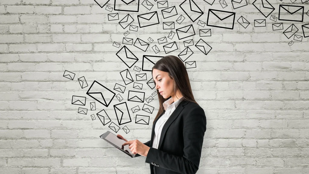 Femme professionnelle utilisant une tablette pour gérer une campagne d’emailing professionnel, symbolisant la communication digitale et la conversion en ligne