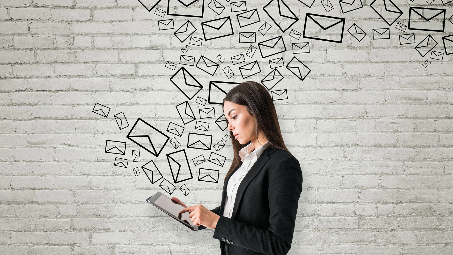 Femme professionnelle utilisant une tablette pour gérer une campagne d’emailing professionnel, symbolisant la communication digitale et la conversion en ligne