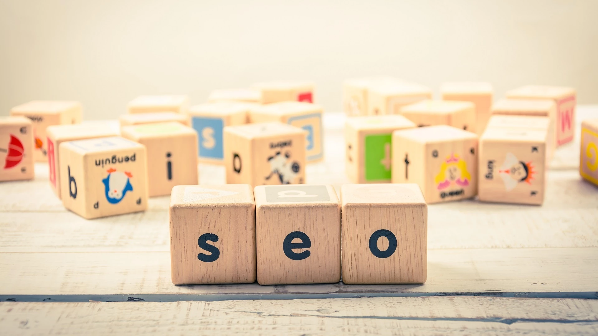 Cubes en bois formant le mot SEO, symbolisant les actions pour améliorer le SEO local et gagner en visibilité dans sa zone géographique