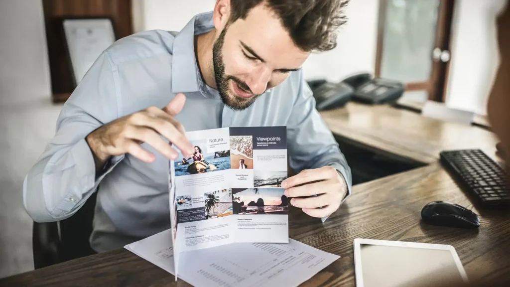 Homme consultant une brochure publicitaire – conseils pour réussir vos brochures et dépliants professionnels