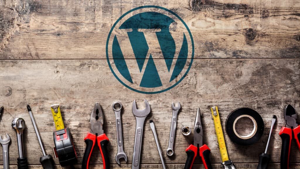 Logo et outils de maintenance WordPress sur fond en bois, symbolisant l’entretien d’un site we