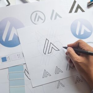 Création d’un logo professionnel sur mesure en cours de dessin, avec déclinaisons graphiques et palette de couleurs.